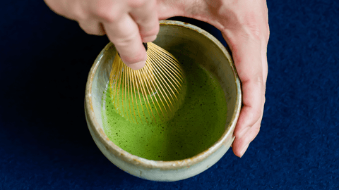 Whisking matcha in a tea bowl with a bamboo chasen