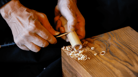 Takayama chasen artisan at Chikumeido Sabun hand-carving a bamboo matcha whisk